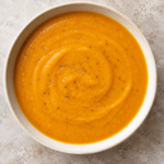 Sopa de calabaza asada triturada y servida caliente.